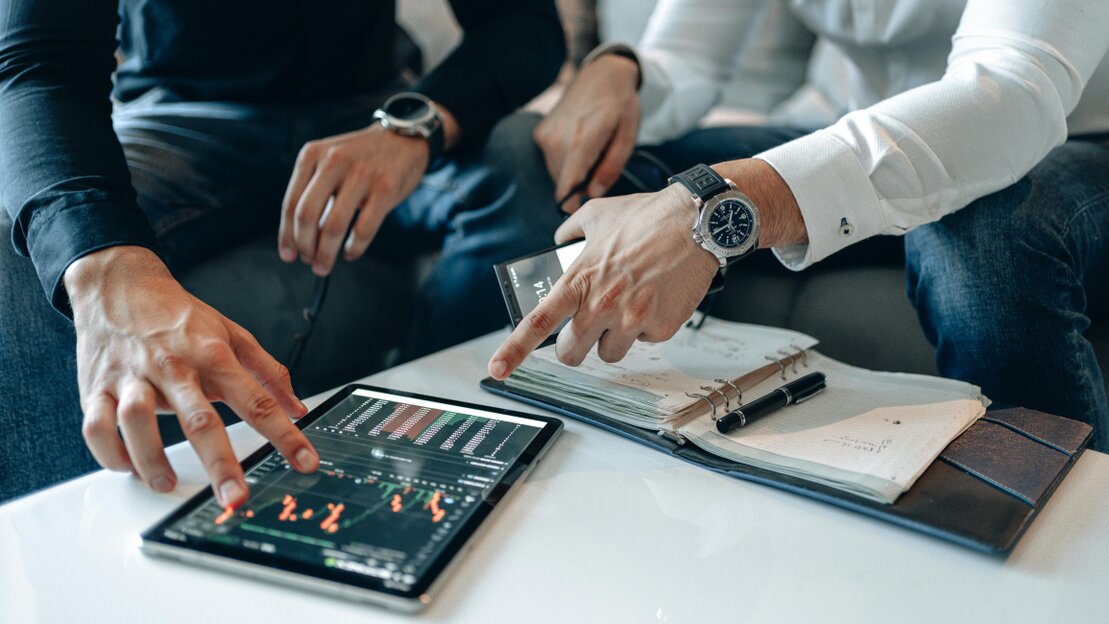 Team di advisory che analizza dati finanziari su schermi e documenti