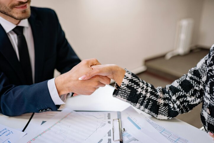 Stretta di mano tra investitore e consulente in un contesto elegante